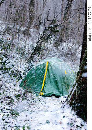 Tent is covered with snow, overnight hikers in forest Tent is covered with snow, overnight hikers in forest 111572794