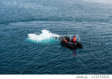 Maneuvering orange lifeboat in water in Arctic waters, Svalbard. Abandon ship drill. Lifeboat training. Man over board drill. Maneuvering orange lifeboat in water in Arctic waters, Svalbard. Abandon ship drill. Lifeboat training. Man over board drill. 111573828
