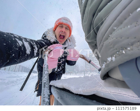 Father walking with his child through a snowy urban setting, emphasizing the joy and simplicity of a winter walk together. 111575189
