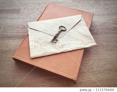 机の上に置かれた古い本と手紙と鍵 111576000