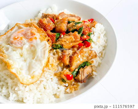 Rice topped with crispy pork belly with Thai basil and fried egg 111576597