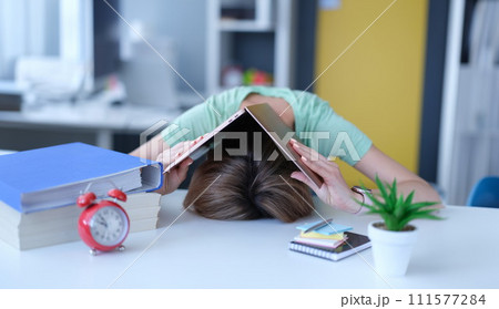 Woman covered her head with laptop and put it on table at workplace 111577284