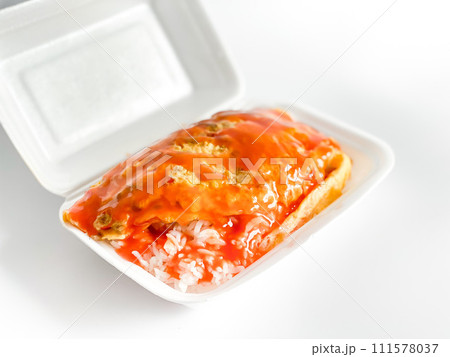 Omelet with pork and chili sauce on rice in the white food tray Omelet with pork and chili sauce on rice in the white food tray 111578037
