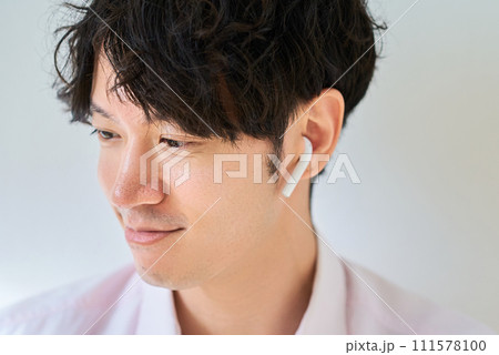ワイヤレスイヤホンを装着した男性 111578100