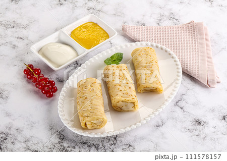 Homemade stuffed pancakes with honey and cream sour 111578157
