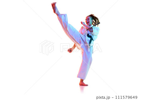Side view portrait of karate fighter, taekwondo master shouting and training in action isolated over white studio background. 111579649