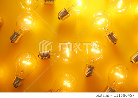 Light bulbs on yellow background, creative pattern. Light, technology, idea concept. Glowing light bulbs 111580457