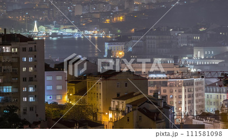Aerial view of Lisboa downtown night timelapse. Panoramic of Baixa, Rossio and Chiado red rooftops from above. Portugal 111581098