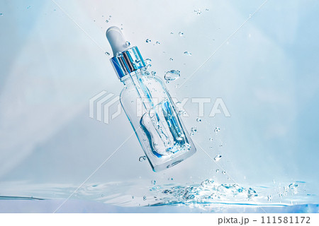 Cosmetic essence in a glass bottle with a pipette in a transparent liquid, water with bubbles. Concept of natural Hydration cosmetics, skin care serum. Scientific developments of modern cosmetics 111581172