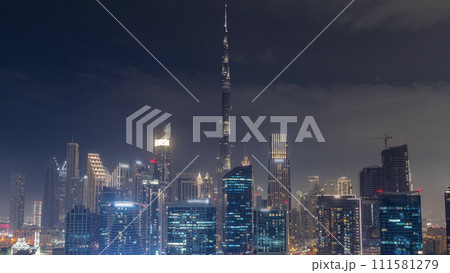 Aerial view to Dubai Business Bay and Downtown with the various skyscrapers and towers day to night timelapse 111581279