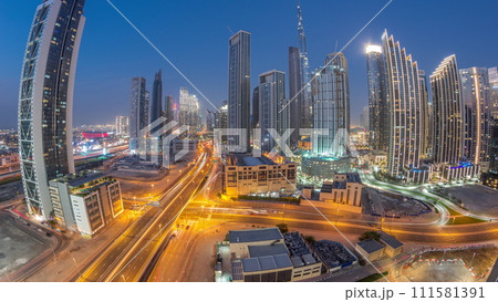 Aerial view of Dubai Downtown skyline with many towers day to night timelapse. 111581391