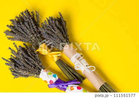 Three bouquets of dried lavender on a yellow background. Three bouquets of dried lavender on a yellow background. 111581577