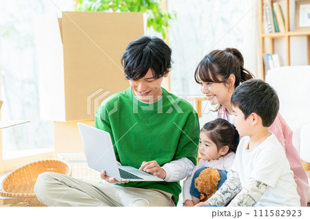 引越しでパソコンを見る若い家族 111582923