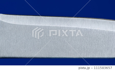 Knife blade close up, isolated on a blue background 111583657