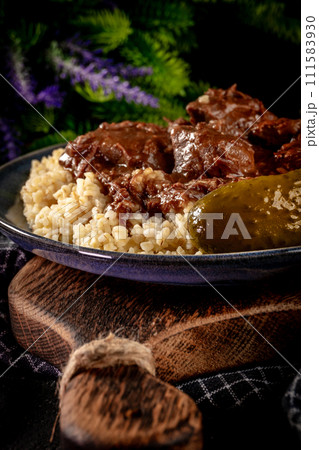 Chunky beef stew with savory sauce, served with bulgur groats. Chunky beef stew with savory sauce, served with bulgur groats. 111583930
