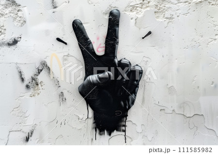 Grunge graffiti on a wall with two fingers painted in black. Spray painted graffiti of hand gesture V sign for victory 111585982