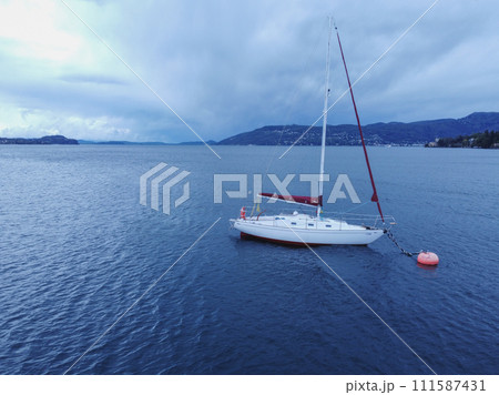Sailboat in the sea in the evening sunlight over beautiful big mountains Sailboat in the sea in the evening sunlight over beautiful big mountains 111587431