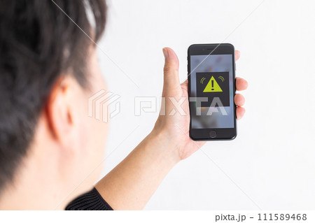 緊急速報を見る男性　A man looking at emergency news 111589468
