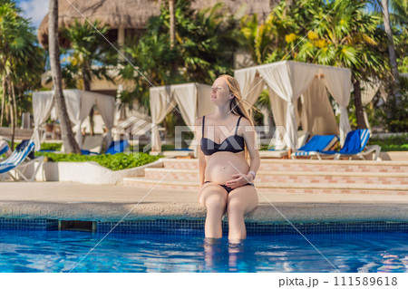 Radiant and relaxed, a pregnant woman finds serenity while enjoying the refreshing embrace of the pool, embracing moments of buoyant joy during pregnancy 111589618