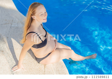 Radiant and relaxed, a pregnant woman finds serenity while enjoying the refreshing embrace of the pool, embracing moments of buoyant joy during pregnancy Radiant and relaxed, a pregnant woman finds serenity while enjoying the refreshing embrace of the pool, embracing moments of buoyant joy during pregnancy 111589811