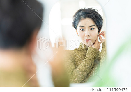 アクセサリーを付ける女性 111590472