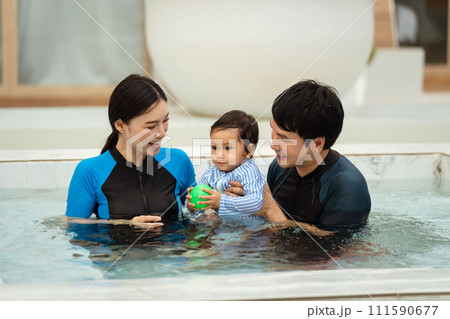 happy family. father and mother with small daughter in swimming pool. 111590677