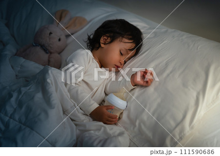 toddler baby sleeping on bed after drinking milk bottle at night toddler baby sleeping on bed after drinking milk bottle at night 111590686