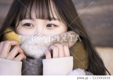 マフラーで顔を隠す若い女性 マフラーで顔を隠す若い女性 111591010
