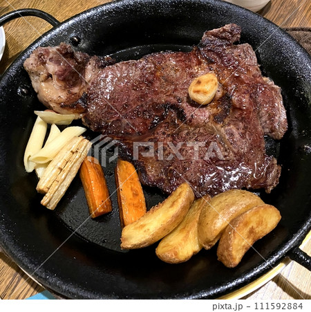 【肉料理】オーブン・グリルプレートで焼かれたボリューム満点のステーキ(真上から) 111592884