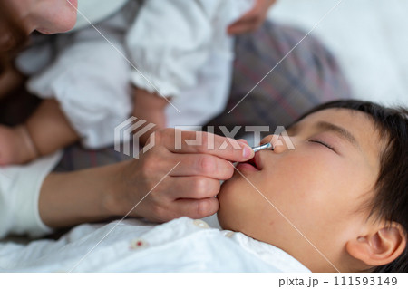 子供の鼻掃除をする母親 111593149