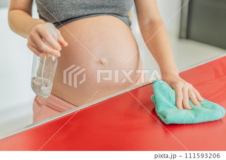 Efficient and dedicated, a pregnant woman tackles kitchen chores, ensuring a clean and organized space, exemplifying resilience and care during her pregnancy 111593206