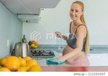 Efficient and dedicated, a pregnant woman tackles kitchen chores, ensuring a clean and organized space, exemplifying resilience and care during her pregnancy 111593207