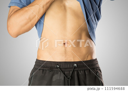 A man pulled up his shirt to reveal his belly. A man pulled up his shirt to reveal his belly. 111594688