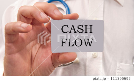 Cash flow text written on a white card in the hands of a businessman Cash flow text written on a white card in the hands of a businessman 111596695