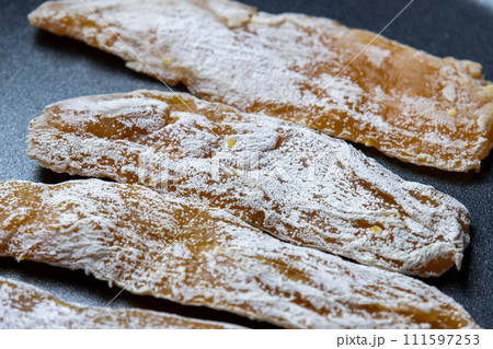 干し芋をフライパンで焼く調理シーン。 111597253