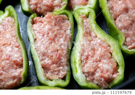 ピーマンの肉詰めをフライパンで焼く調理シーン。 111597679