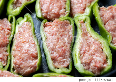 ピーマンの肉詰めをフライパンで焼く調理シーン。 111597681