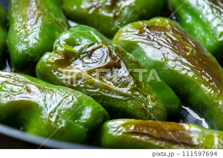 ピーマンの肉詰めをフライパンで焼く調理シーン。 111597694