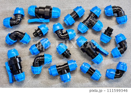 Polypropylene compression clamping fittings for pipeline system made of HDPE pipes laid out on gray slate sheet. Polypropylene compression clamping fittings for pipeline system made of HDPE pipes laid out on gray slate sheet. 111599346