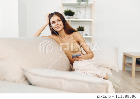 Sofa Woman Holding Phone, Smiling Home Relaxation on Couch. Sofa Woman Holding Phone, Smiling Home Relaxation on Couch. 111599396