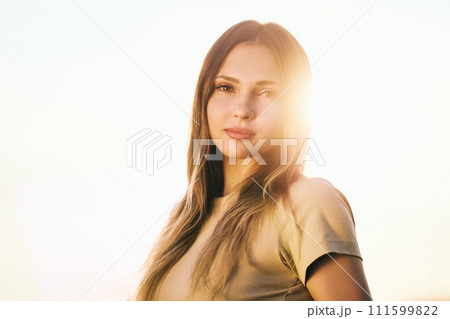 Portrait photograph of young Caucasian woman in backlight. 111599822