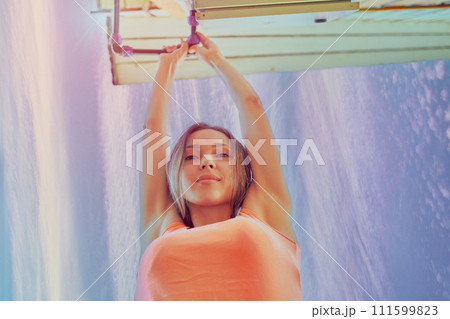 Tightening nut of compression fitting on an external water pipe in country house to eliminate leak, 26 year old European woman is repairing pipeline. Tightening nut of compression fitting on an external water pipe in country house to eliminate leak, 26 year old European woman is repairing pipeline. 111599823