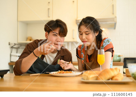 Romantic couple enjoying lunch in the kitchen. Love, relationships and food concept. Romantic couple enjoying lunch in the kitchen. Love, relationships and food concept. 111600145
