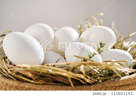 Wicker basket with farm natural white eggs. 111601142