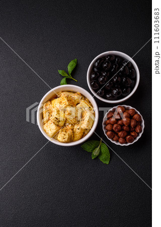 Delicious soft white feta cheese with salt, spices and herbs on a dark concrete background 111603683