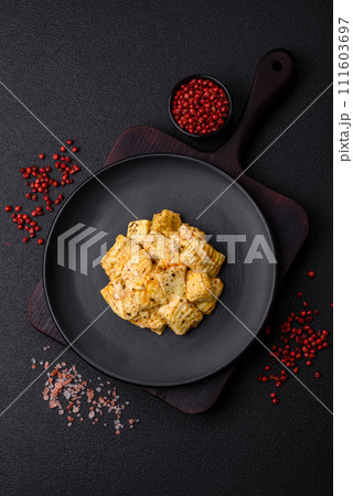 Delicious soft white feta cheese with salt, spices and herbs on a dark concrete background 111603697