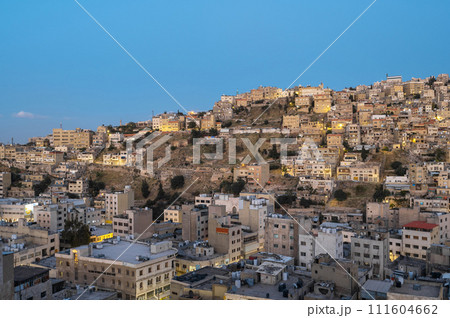 Captivating skyline of Amman, Jordan traditional houses atop a picturesque hill during blue hour 111604662