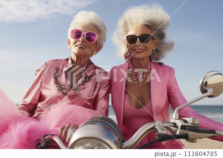 Portrait of an mature couple of women in pink clothes on a motorcycle valentine's Day concept Portrait of an mature couple of women in pink clothes on a motorcycle valentine's Day concept 111604785