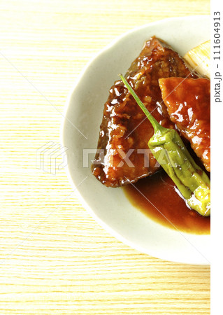 ブリの照り焼きと素揚げのししとうと長ねぎを俯瞰で撮影 111604913
