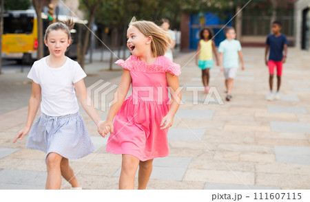 Two girls walking together outdoors Two girls walking together outdoors 111607115